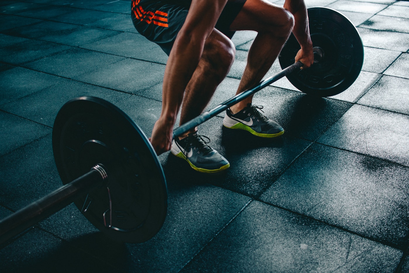 Barbell at rest in a low-lit gym — placeholder image until founder photography is finalized.